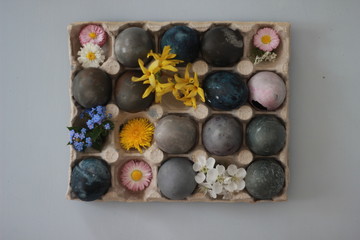 Colored Easter eggs and spring flowers in a cardboard box