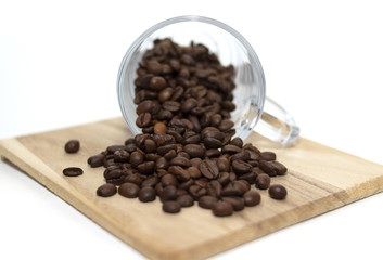 Scattered coffee beans. Glass cup. White background
