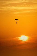 Fototapeta na wymiar Man parachuting at sunset