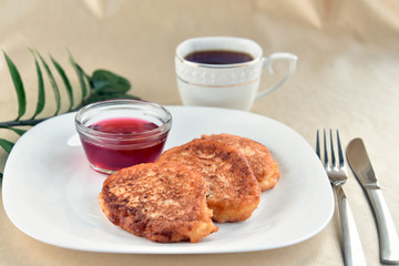 Fritters on a white plate with cherry sauce