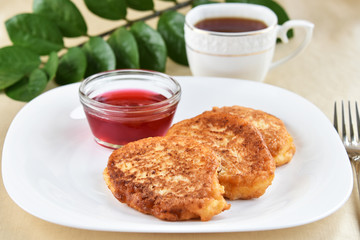 Fritters on a white plate with cherry sauce