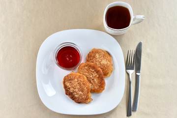 Fritters on a white plate with cherry sauce
