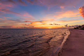 Sunset on of the coastline on Florida beach empty beach dramatic pastel sky illuminating the beach and waves