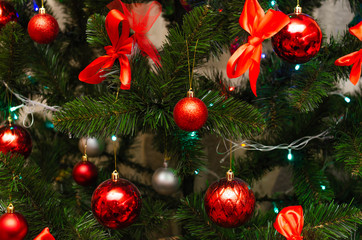 Christmas tree decoration toys. Balls, red bows on the Christmas tree and New Year's wreath. Merry Christmas. Golden star on the Christmas tree. Decorations in macro. Flare. Family Holidays Beauty.