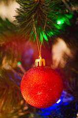 Christmas tree decoration toys. Balls, red bows on the Christmas tree and New Year's wreath. Merry Christmas. Golden star on the Christmas tree. Decorations in macro. Flare. Family Holidays Beauty.