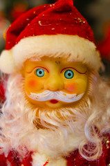 Toy Santa Claus, on the background of the New Year tree, and on the background of the New Year star on the Christmas tree. Toy Santa in close-up. Christmas decoration. Celebration.