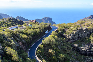 Fototapeta na wymiar Cars driving on mountain zig-zag road in the island Tenerife, Canary, Spain. Starts in Masca and finishes in Santiago del Teide