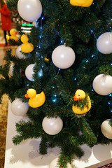 Christmas decorations on the Christmas tree. Duck bath and white balls.