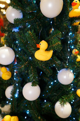 Christmas decorations on the Christmas tree. Duck bath and white balls.