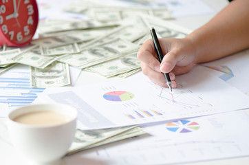 stock graph report with pen and  money,clock,coffee