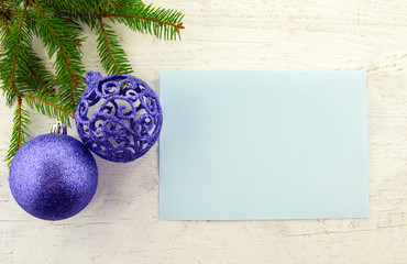 It's Christmas time! Holiday card with glittering decorations and Christmas tree on a white wooden background.