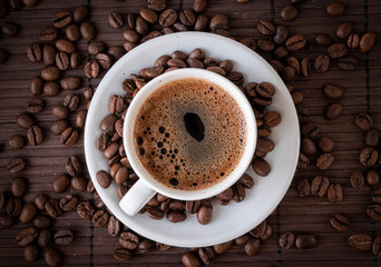Coffee cup and a scattering of coffee beans