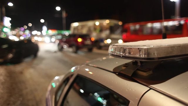 A patrol car with running LED flashlights on the background of a traffic accident in the winter in the evening. Police flasher