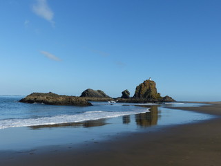 Rocks on a beach with reflection in the water