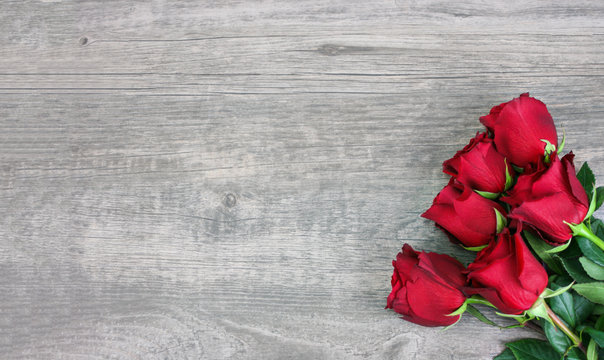 Valentine's Day Holiday Beautiful Red Flower Roses Bouquet Over Wood Texture Rustic Background Horizontal with Copy Space