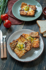 Grilled sandwich with egg, vegetables and bacon on a dark wooden background. Delicious breakfast. Place for text.