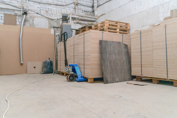 a lot of wooden sheets stacked on a wooden pallet in a warehouse, industrial premises