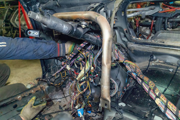 Mechanic electrician checking repairing upgrading wiring. Auto service workshop. Regular preventive...
