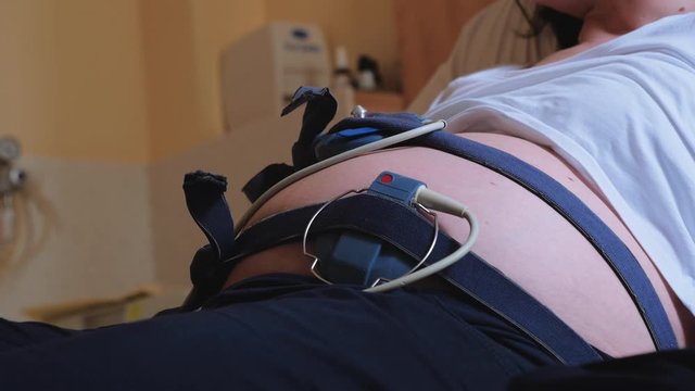 Woman in Labor Room with Monitor Straps on Stomach