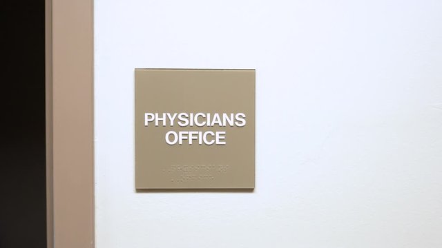 Signs on wall in medical office hospital. slider movement of establishing shot for room inside doctors office.
