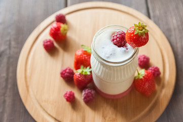 Homemade yogurt in a jar close-up. Fermented milk product with strawberries and copy space.
