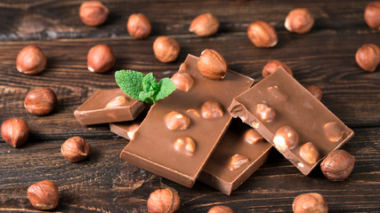 chocolate with hazelnuts on a wooden background