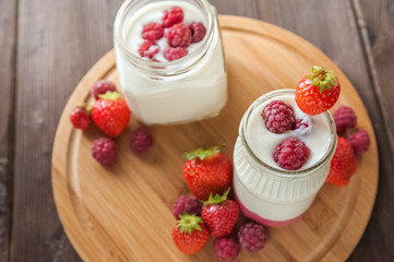 Homemade yogurt in a jar close-up. Fermented milk product with strawberries and copy space.