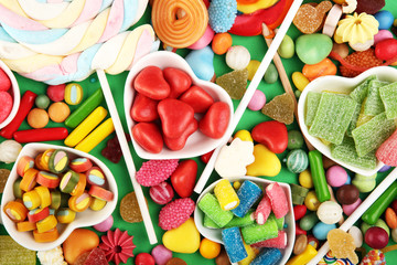 Fototapeta na wymiar candies with jelly and sugar. colorful array of different childs sweets and treats on green background