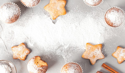 Cupcakes and cookies on a grey background, top view, copy space. Pastry background.
