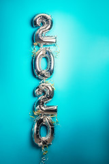 Balloon Bunting for celebration of New Year 2020 made from Silver Number Balloons. Holiday Party Decoration or postcard concept with top view and copy space. Toned in blue color