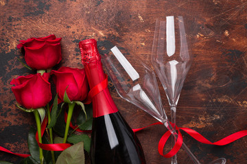 Valentine's day greeting card with red rose flowers and champagne glasses on wooden background Copy space Top view
