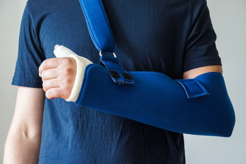 Man with plaster cast on broken thumb,broken wrist, broken hand on arm sling