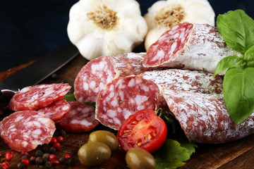 thinly sliced salami on a wooden texture on the background.