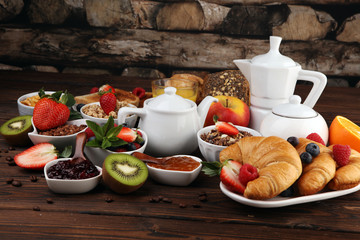 Breakfast served with coffee, orange juice, croissants, cereals and fruits. Balanced diet. Continental breakfast with granola and fruits