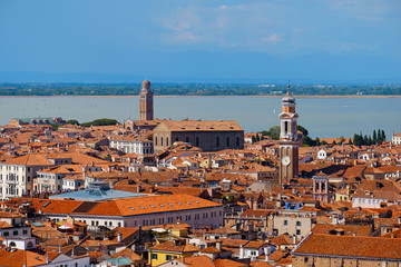 Fototapeta na wymiar Aerial view of Venice, Italy. Top view of Venice from the Campanile tower of Saint Mark's Cathedral (Basilica di San Marco) and Doges' Palace. Cityscape panorama of Italian houses with red roofs.