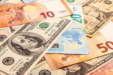 Euro and dollars paper money in cash. The two leading currencies of the world are US dollars and euros. Texture of multiple US dollars and euros banknotes. Background from paper money.