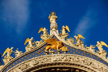 Fototapeta premium Basilica di San Marco under blue sky, Venice, Italy. Saint Mark Basilica and Doge's Palace. Cathedral of San Marco. Roof architecture details with lion, symbol of the City of Venice. 