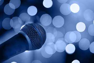 Microphone on stage with bokeh lights.