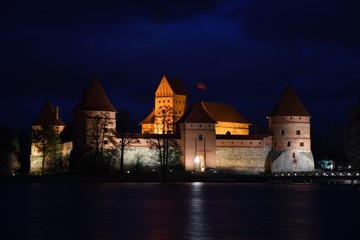 Medieval castle of Trakai, Vilnius, Lithuania, Eastern Europe, located between beautiful lakes and nature with wooden bridge and lights, at night