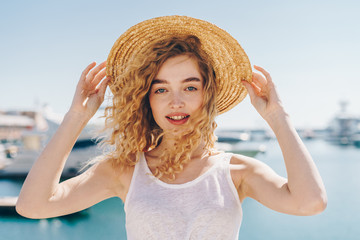 cute blonde in a hat on the background of the sea and ships