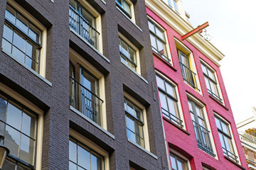Bottom view of traditional and typical bright building showing Dutch architectural style in Amsterdam. It is a sunny autumn day.