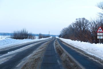 Winter poorly cleared road. Road in the countryside strewn with snow. Snowdrifts