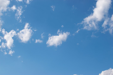 Beautiful white cumulus clouds slowly floating against a clear blue sky