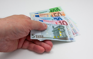 Various euro bills held in a hand