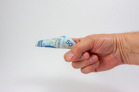 A 50 Polish zloty banknote rolled into cone shape and stuk o the index finger of a hand