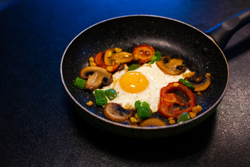 Freshly fried eggs with vegetables in a pan