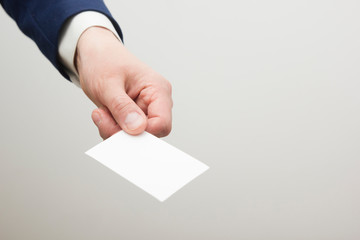 Hand holding white business card on white background