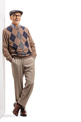Elderly gentleman leaning on a wall and smiling at the camera