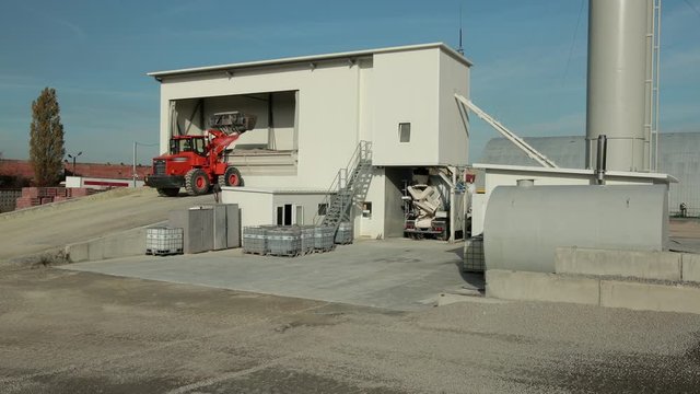 Tractor can be seen dropping product in storage container which is also with roof. They keep it here for protection then it will be transported to desired destination.