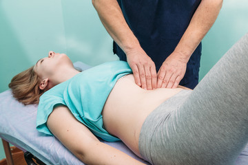 Fototapeta na wymiar therapist applying pressure on stomach detail of hands massaging female belly